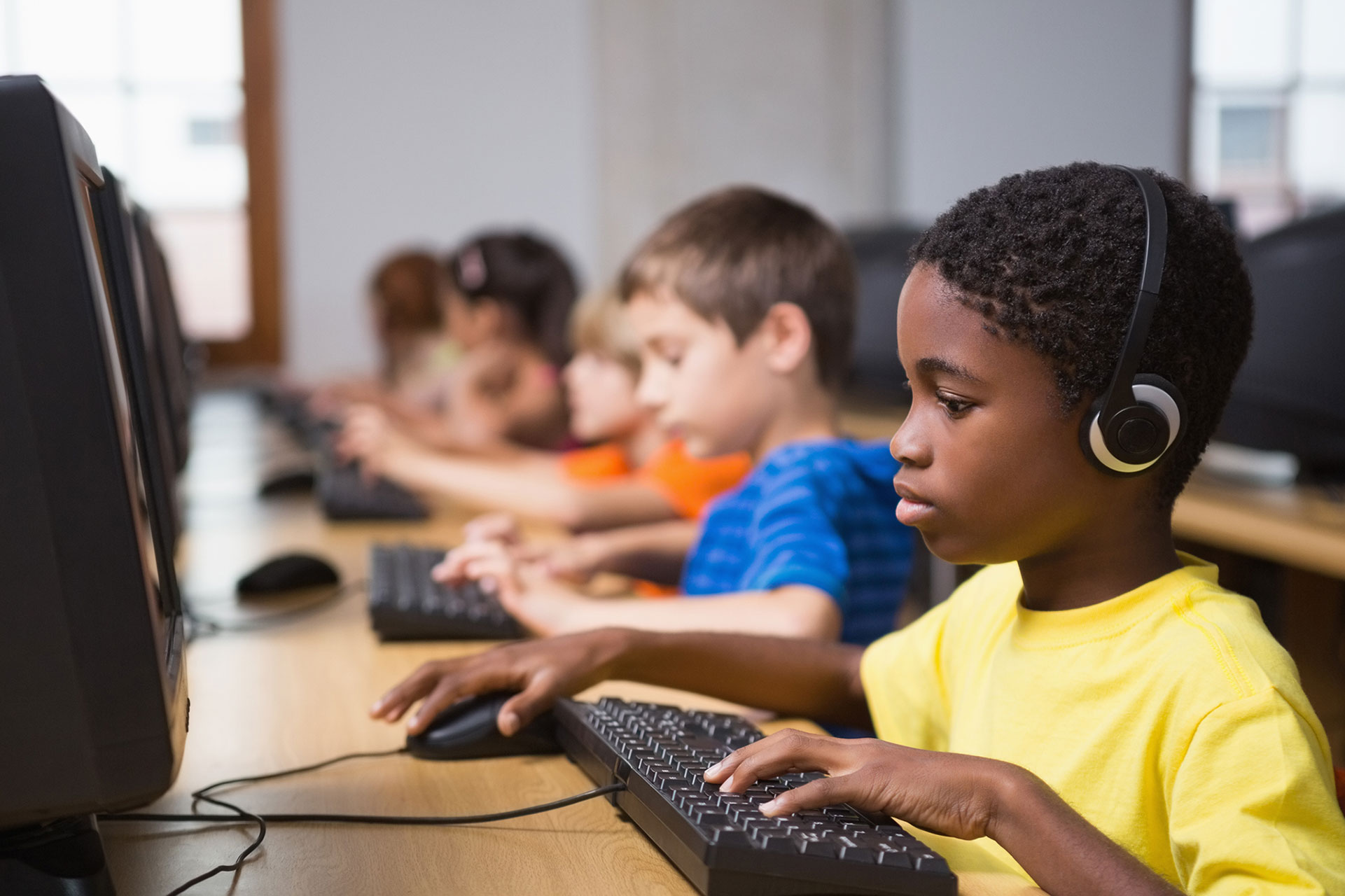 Young children working on desktop computers